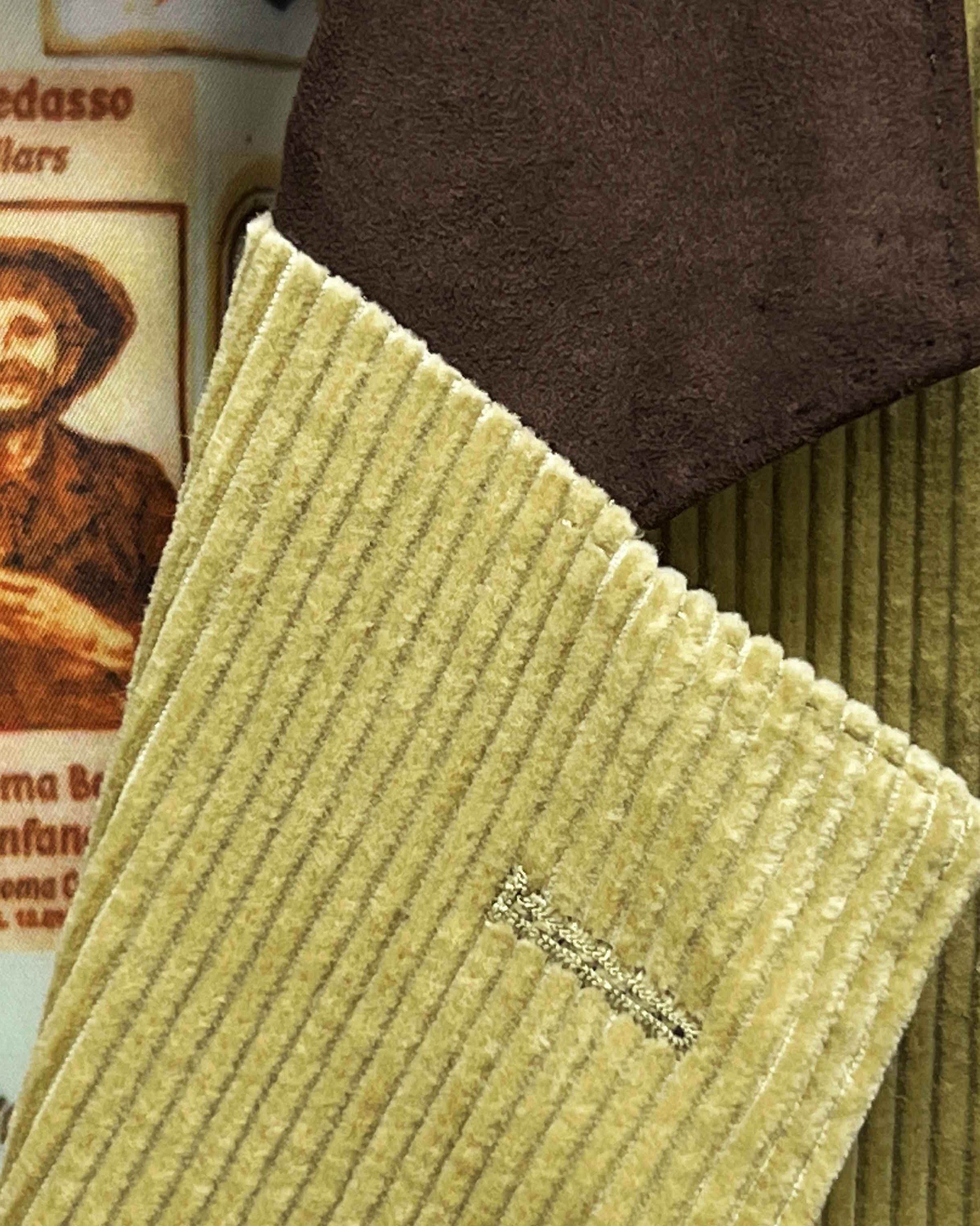 Close-up view of tan corduroy sport coat showing dark brown suede collar detail with hand-finished stitching