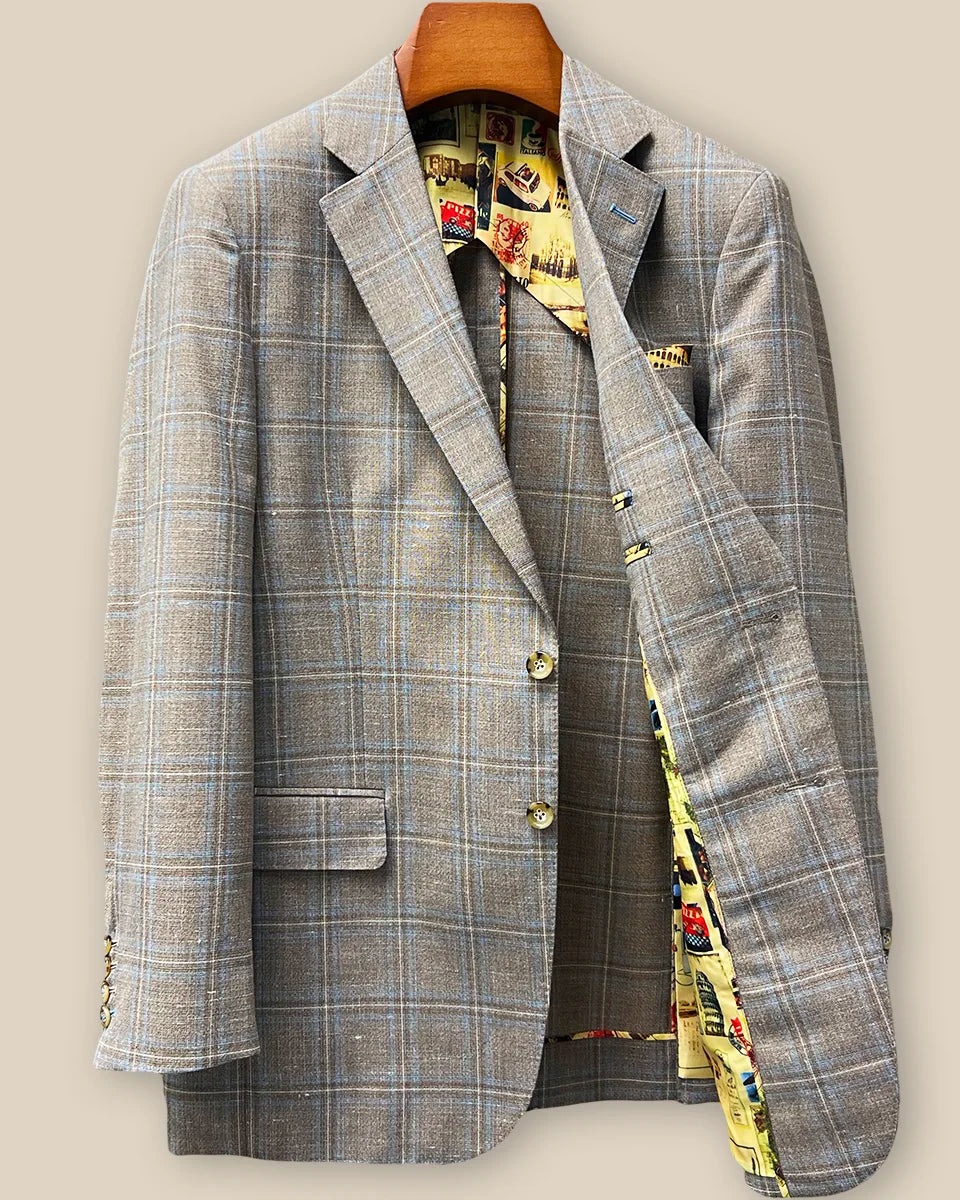 Interior left side of tan blue windowpane sport coat displaying vibrant yellow multicolored mosaic lining with inner pocket
