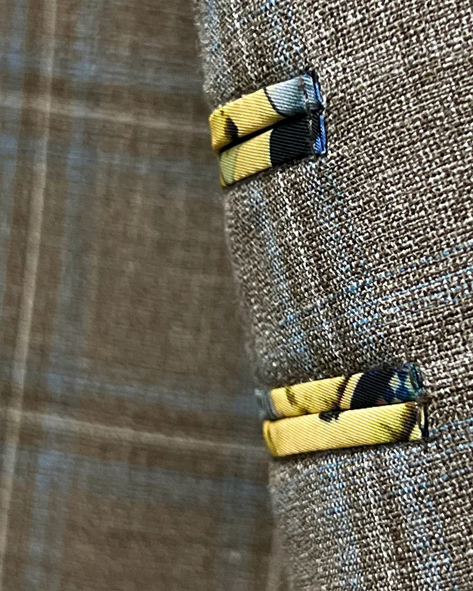 Close-up fabric detail showing tan base with blue windowpane check pattern and weave structure