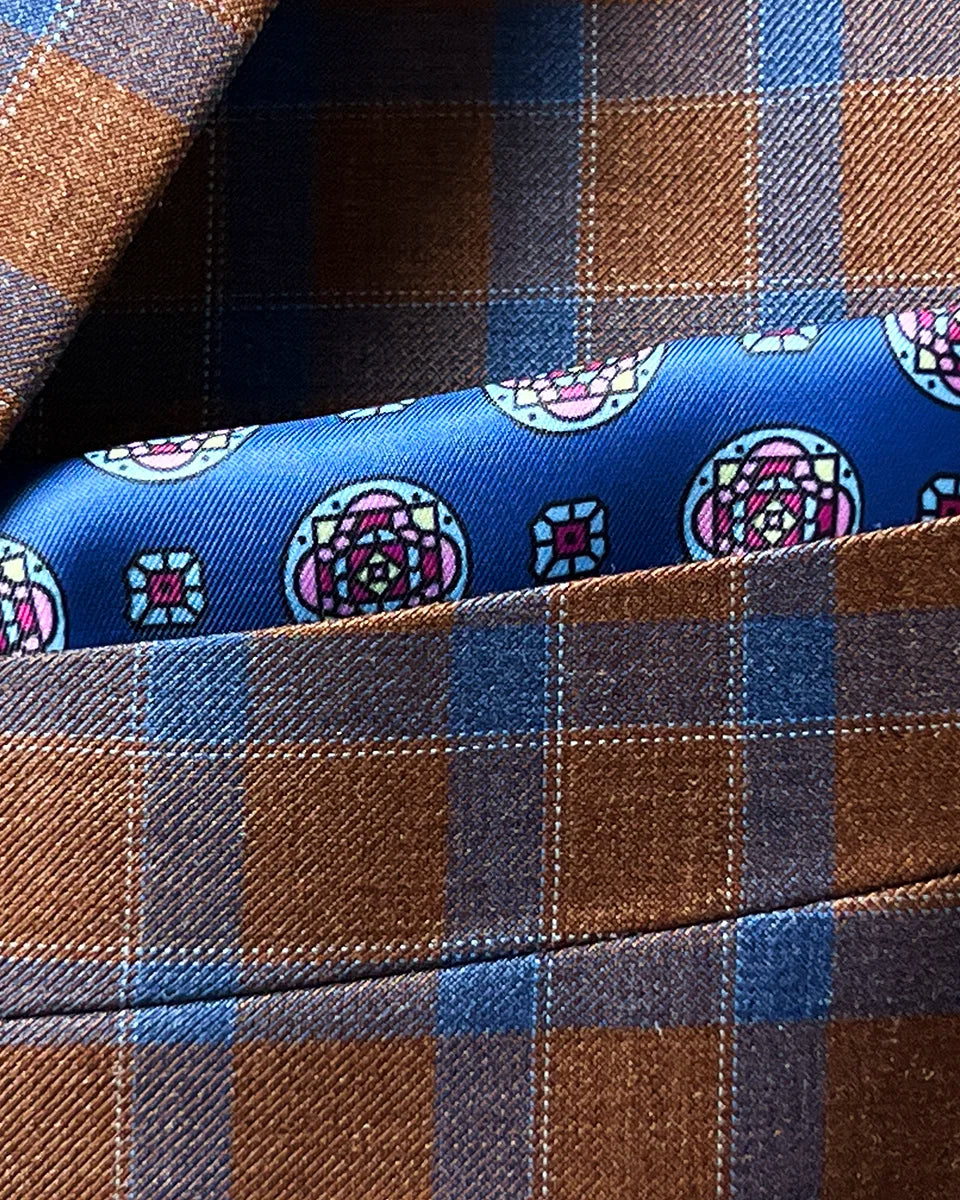 Integrated pocket square detail showing coordinated styling with dark blue geometric pattern complementing the jacket's check design