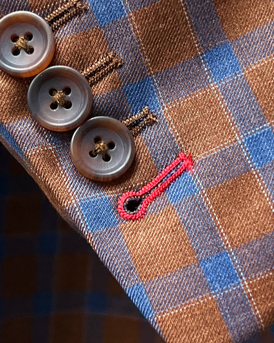Working sleeve buttonholes with red contrast stitching demonstrating authentic custom tailoring and functional design elements