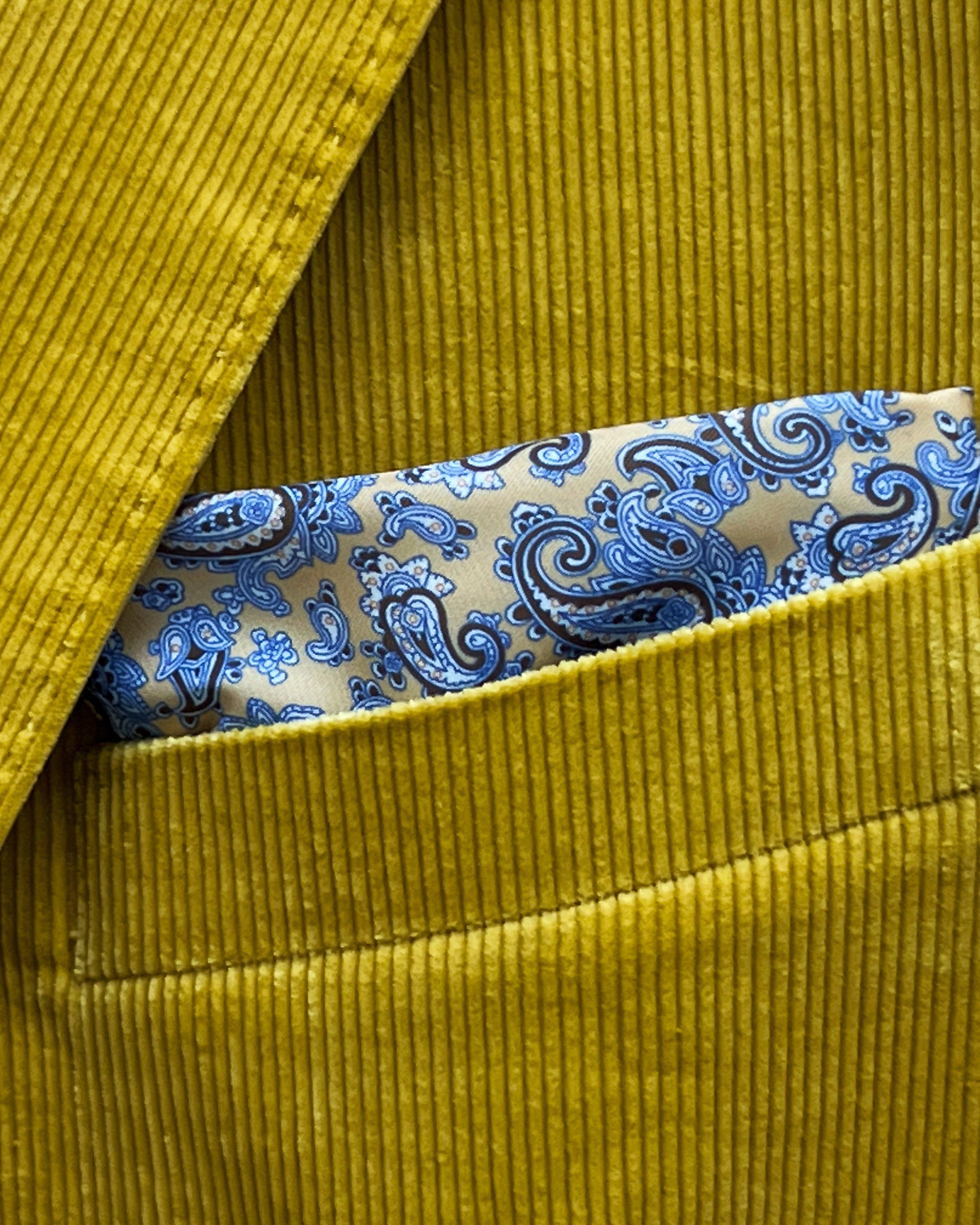 Breast pocket of warm mustard yellow corduroy sport coat with built-in pocket square holder and hand-finished edges