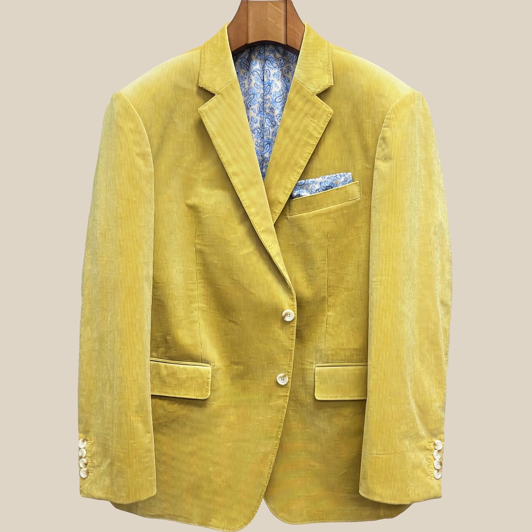 Front button panel of warm mustard yellow corduroy sport coat featuring light cream horn buttons with caramel swirl and hand pick stitching