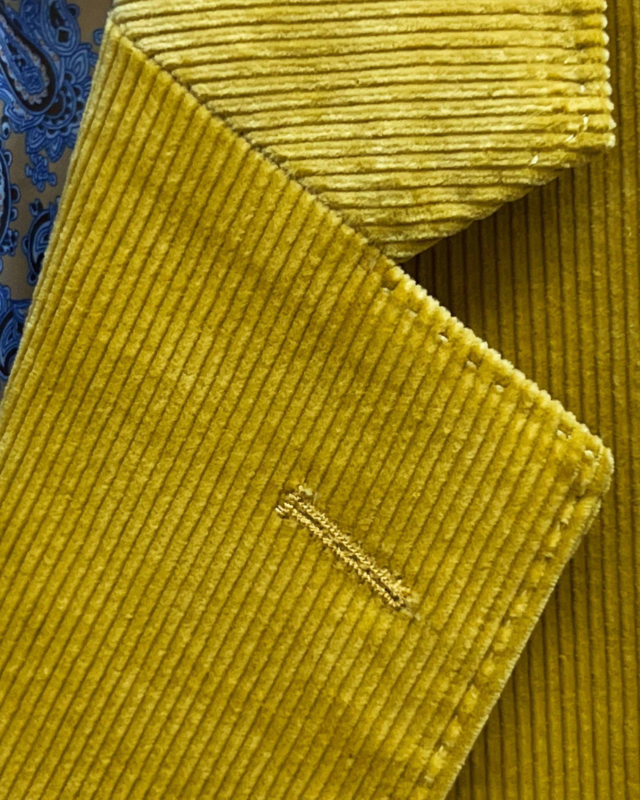 Classic notch lapel detail on warm mustard yellow corduroy sport coat showing hand pick stitching and distinctive 10 wale texture