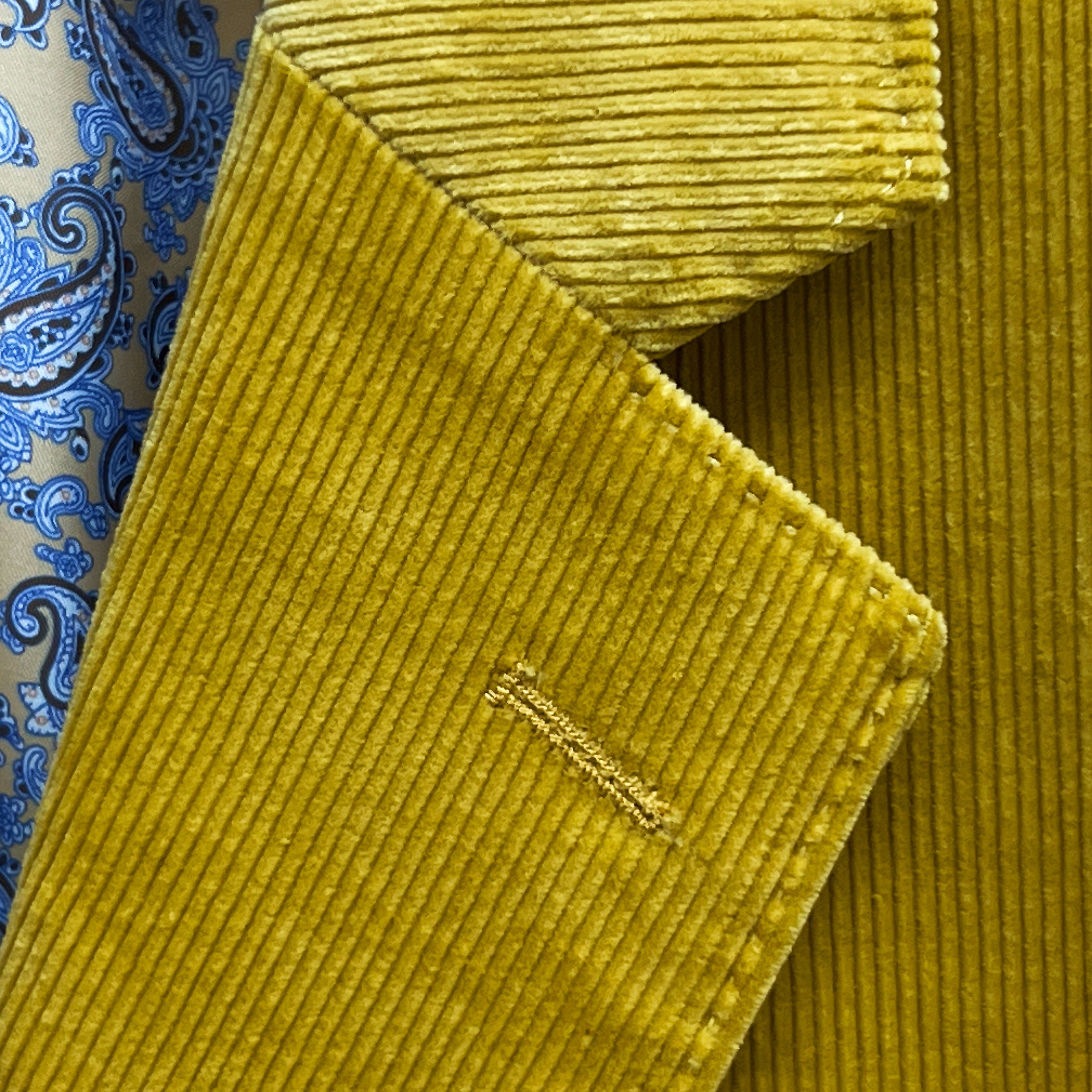 Classic notch lapel detail on warm mustard yellow corduroy sport coat showing hand pick stitching and distinctive 10 wale texture