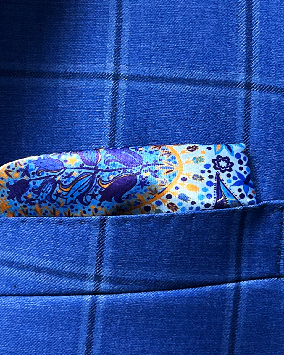 Breast pocket of royal blue windowpane suit jacket with built-in pocket square holder and hand-finished edges