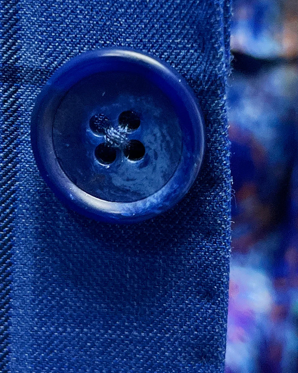Close-up of medium blue horn buttons on royal blue windowpane suit jacket showing natural marble-like patterns