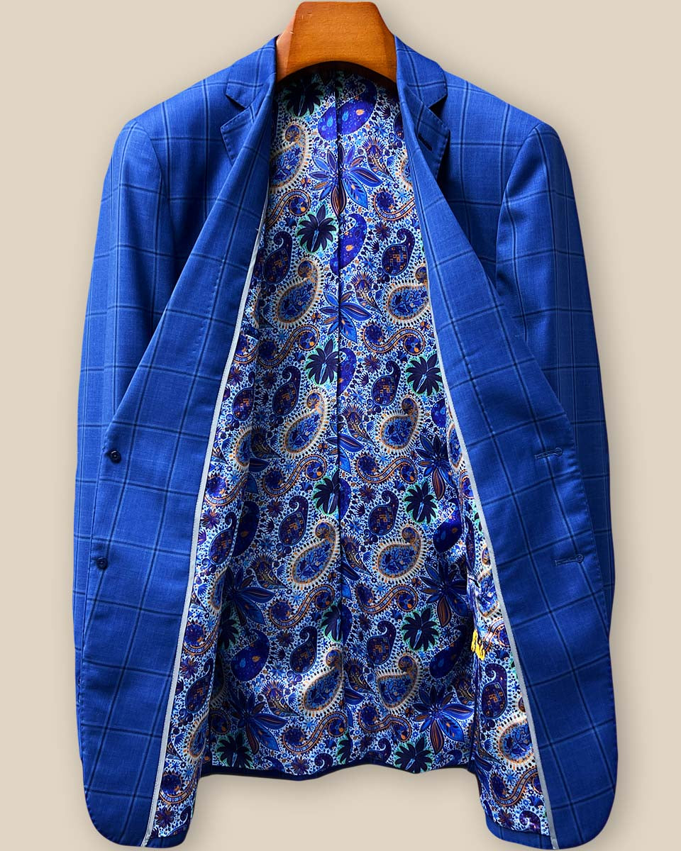 Full interior view of custom suit jacket showcasing luxurious light blue, navy and gold paisley lining with Westwood Hart branding