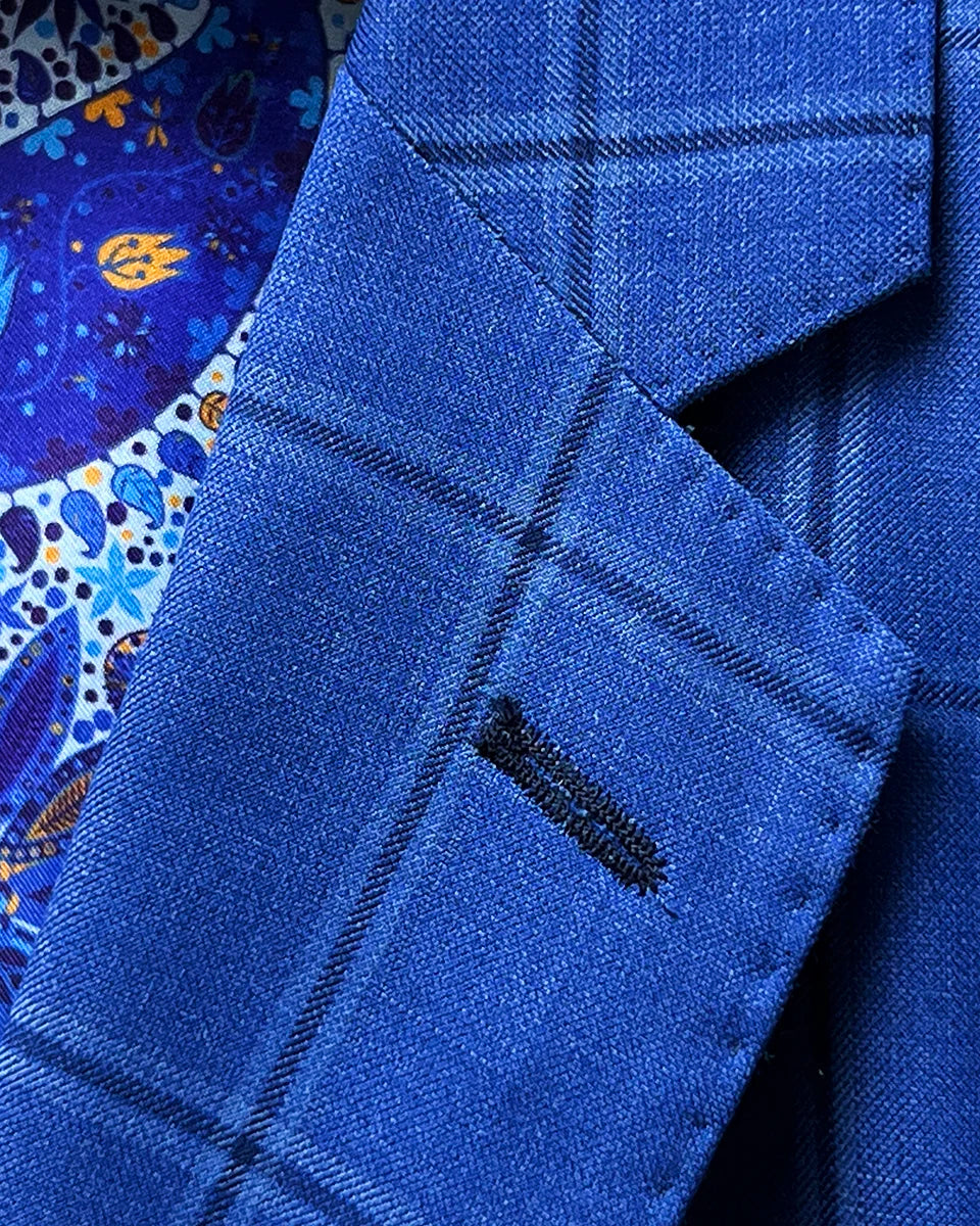 Classic notch lapel detail on royal blue windowpane suit jacket showing hand pick stitching and navy check pattern