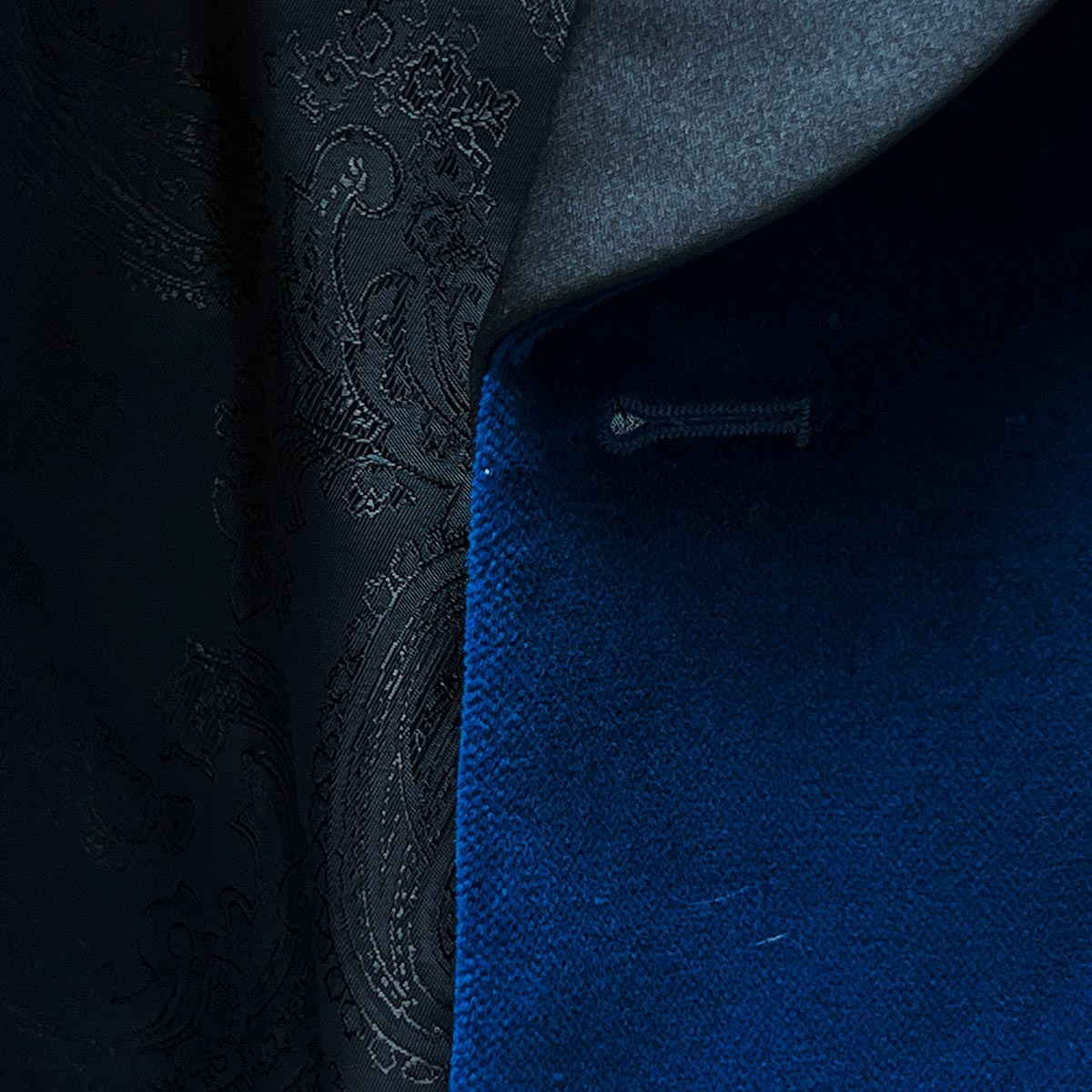 Close-up of a buttonhole on a blue tuxedo velvet blazer, a classic attire for an elegant dinner or a sophisticated evening event.