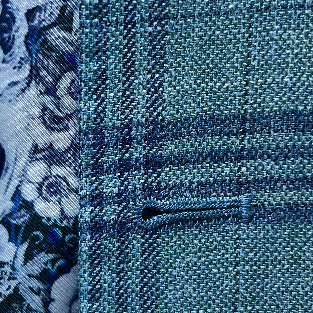 Detailed view of the men's sportcoat's buttonhole stitching.