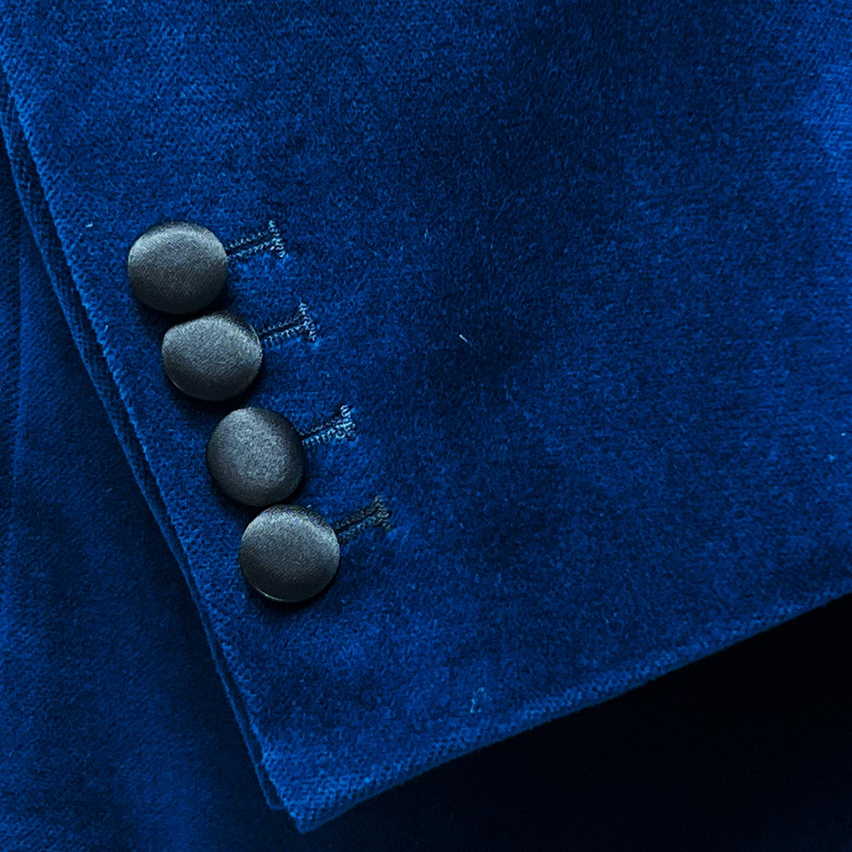 Functional sleeve buttonholes on a velvet tuxedo suit, offering a blend of traditional craftsmanship and modern sophistication.
