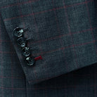 Close-up detail of the grey and red windowpane check pattern on a men's charcoal grey suit.