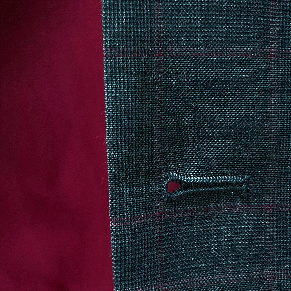 Button detail on a grey windowpane suit, focusing on its high-quality craftsmanship.