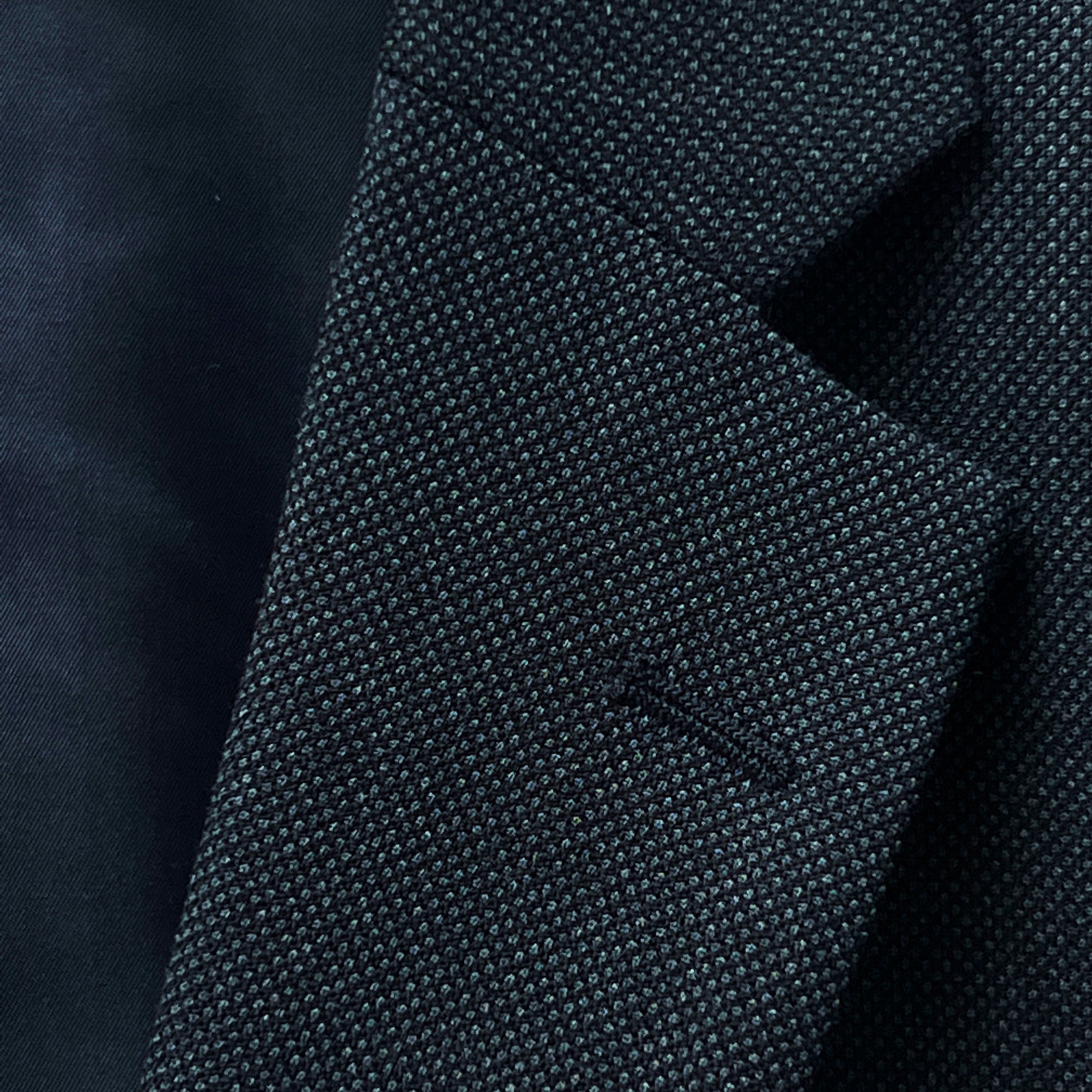 Dark grey birdseye custom suit, detailed view of the lapel and buttonhole, ideal for online design