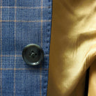Functional sleeve buttonholes in a stone blue business suit.