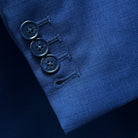 Close-up of the functional sleeve buttonholes on the cobalt blue sharkskin jacket, with elegant blue marble horn buttons.