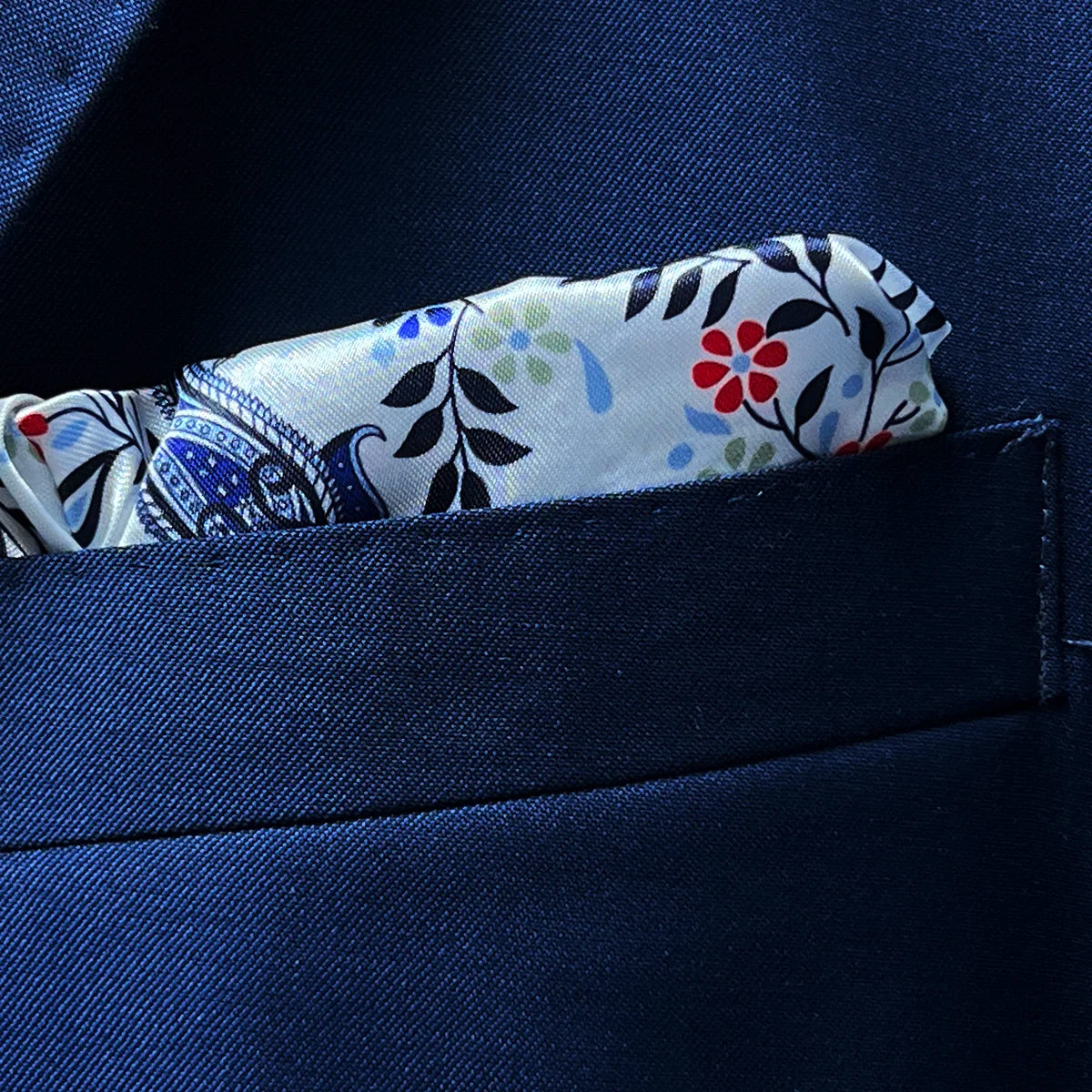 Close-up of suit jacket breast pocket with built-in pocket square matching the jacket's lining