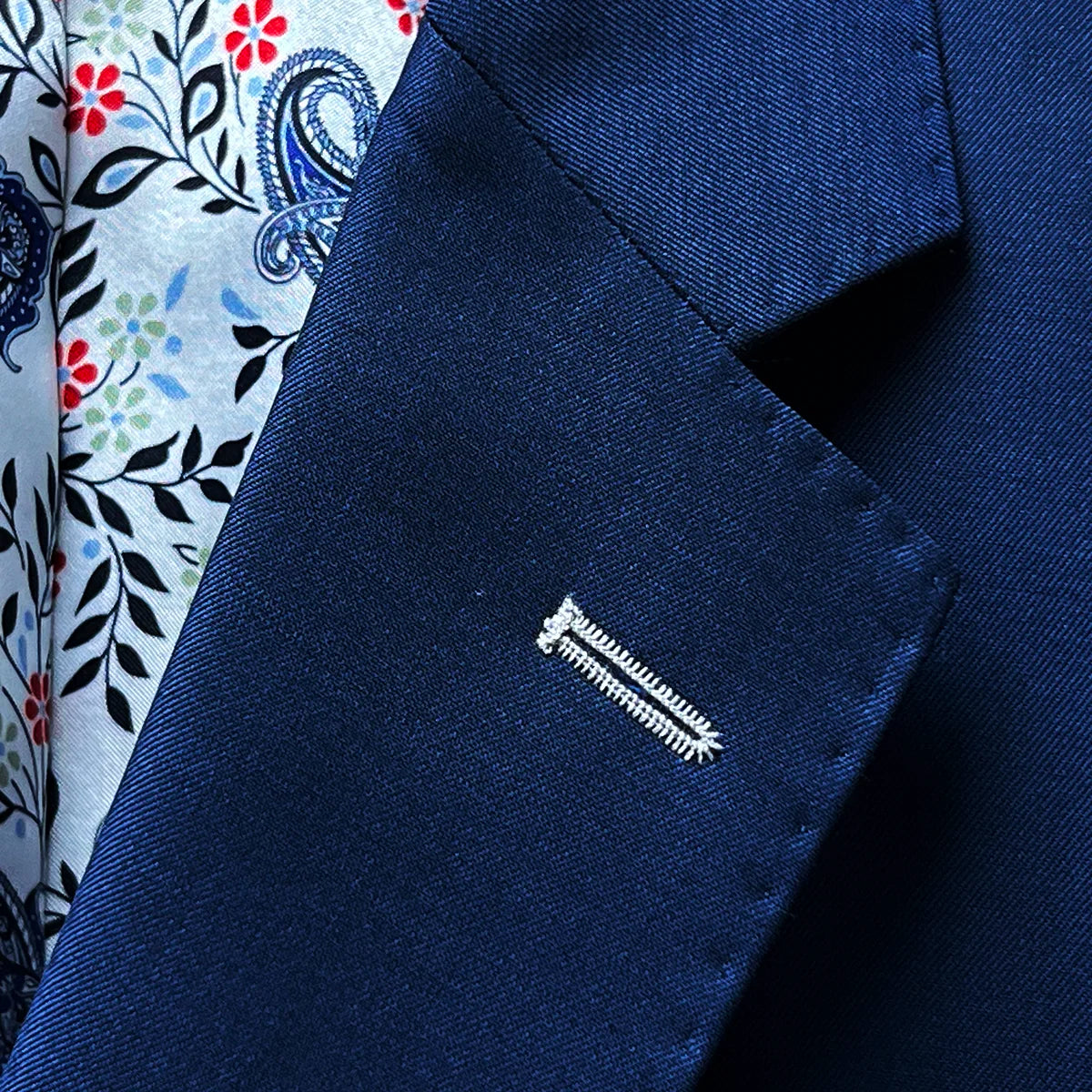 Detailed view of the suit's notch lapel, showcasing the sharkskin texture and white contrast buttonhole