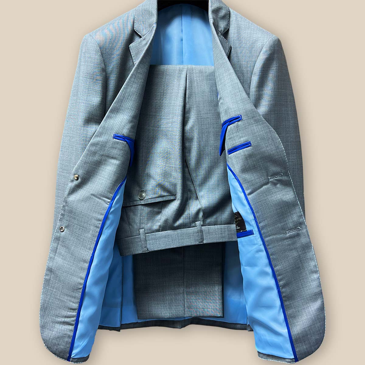 Full view of the two-piece light grey sharkskin suit with notch lapel, straight flap pockets, and grey marble horn buttons.