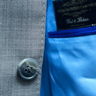 Hand-sewn sky blue pick stitching detail on the light grey sharkskin suit jacket.