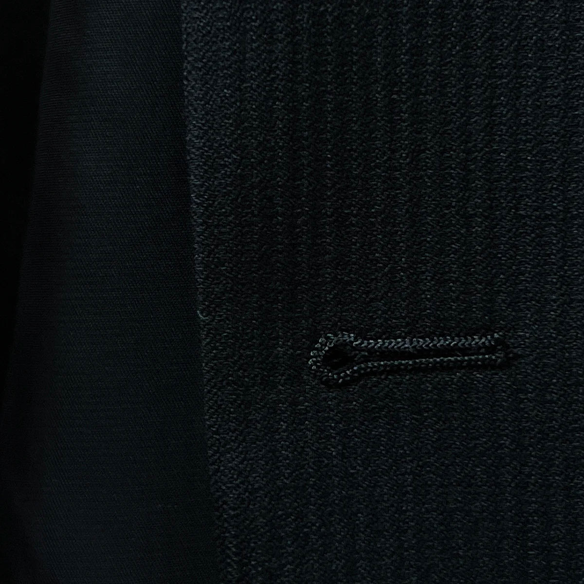 Image highlighting the buttonhole stitching on the jacket, demonstrating fine craftsmanship.