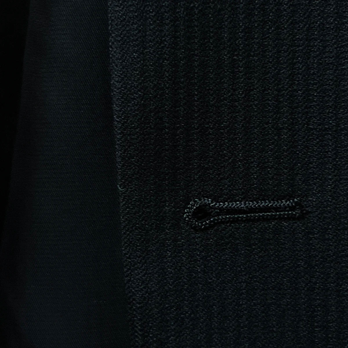 Image highlighting the buttonhole stitching on the jacket, demonstrating fine craftsmanship.