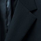 Close-up of the notch lapel, showcasing the black herringbone design and tailored finish.