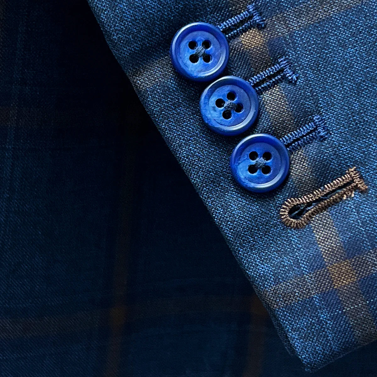 Close-up of the functional sleeve buttonholes with brown accent stitching.