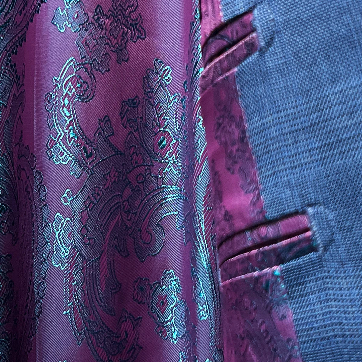View of the flash linings inside the suit jacket, highlighting the vibrant paisley pattern.