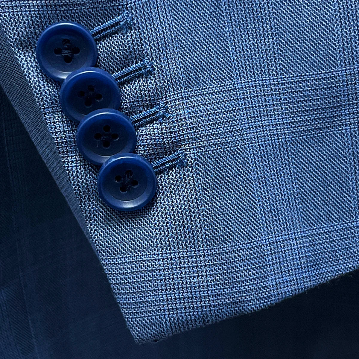 Close-up of the functional overlapping kissing buttons on the sleeve of the suit jacket.