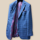 The inside right view of the suit jacket, with a focus on the intricate pink and purple paisley lining.