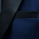 View of the built-in pocket square in the tuxedo jacket's pocket, complementing the navy blue plain fabric.