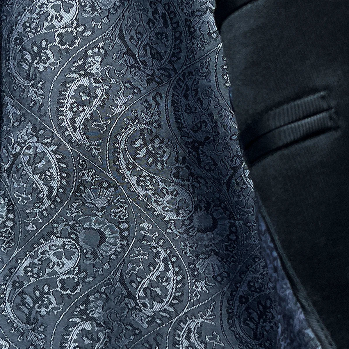 Image of the tuxedo jacket with flash linings, showing the contrast between the navy blue plain fabric and silver paisley lining.