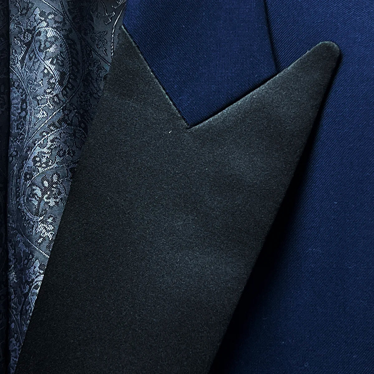 Close-up of the peak lapel, emphasizing the elegant black satin facing and precise tailoring.