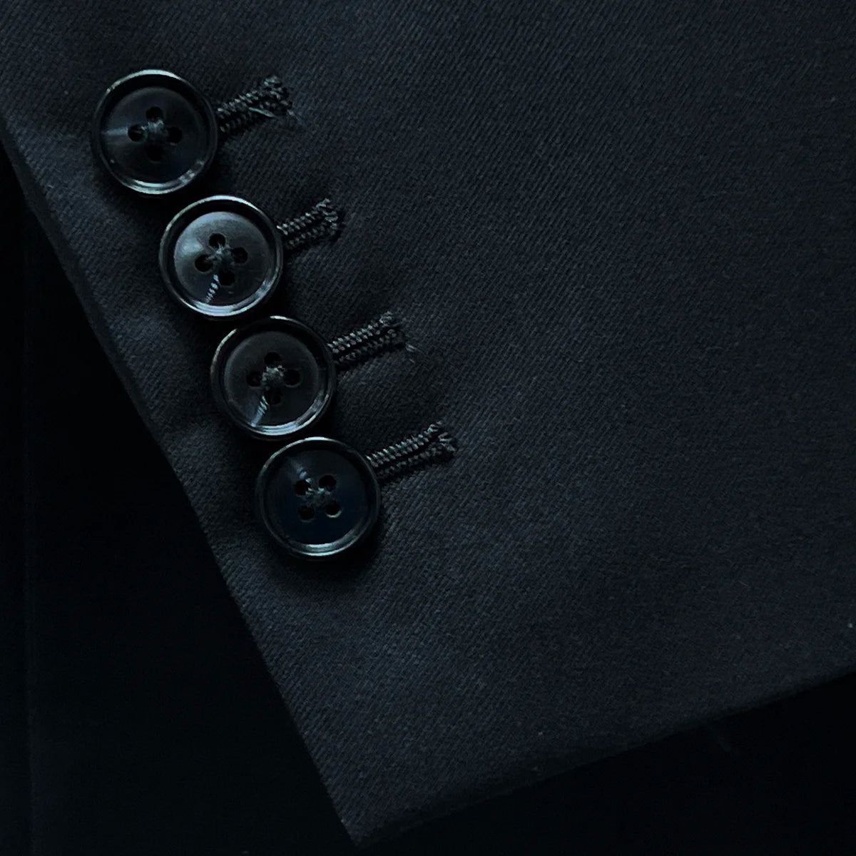 Detailed view of the functional sleeve buttonholes, illustrating the precision stitching and black horn buttons.