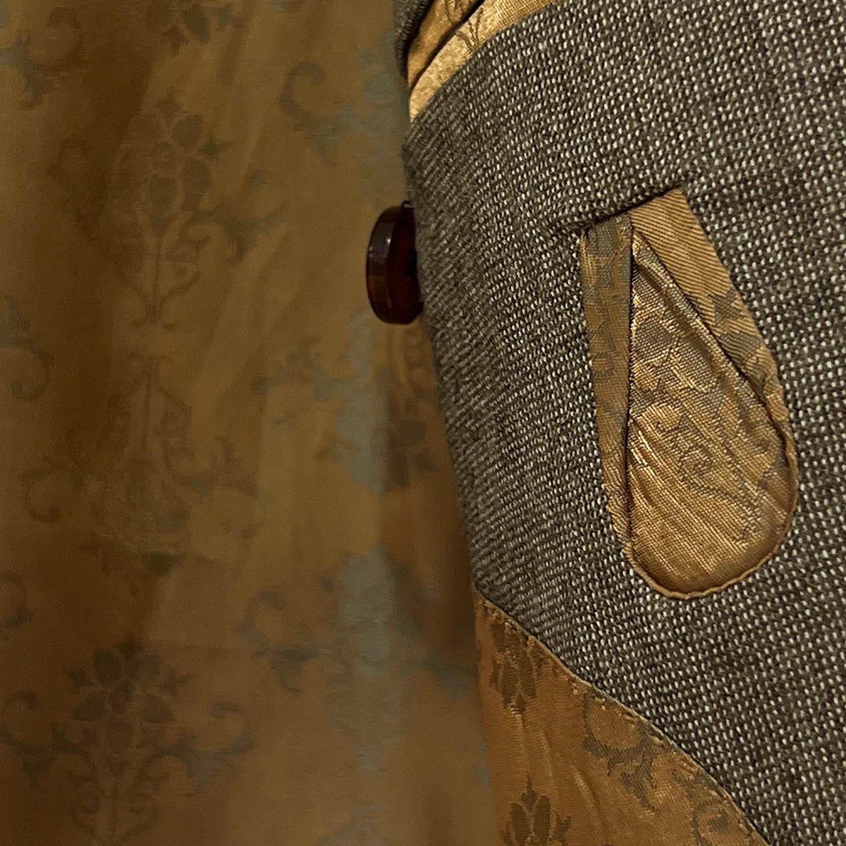 View of the flash linings inside the Westwood Hart brown nailhead men's suit jacket, featuring a luxurious gold patterned design.