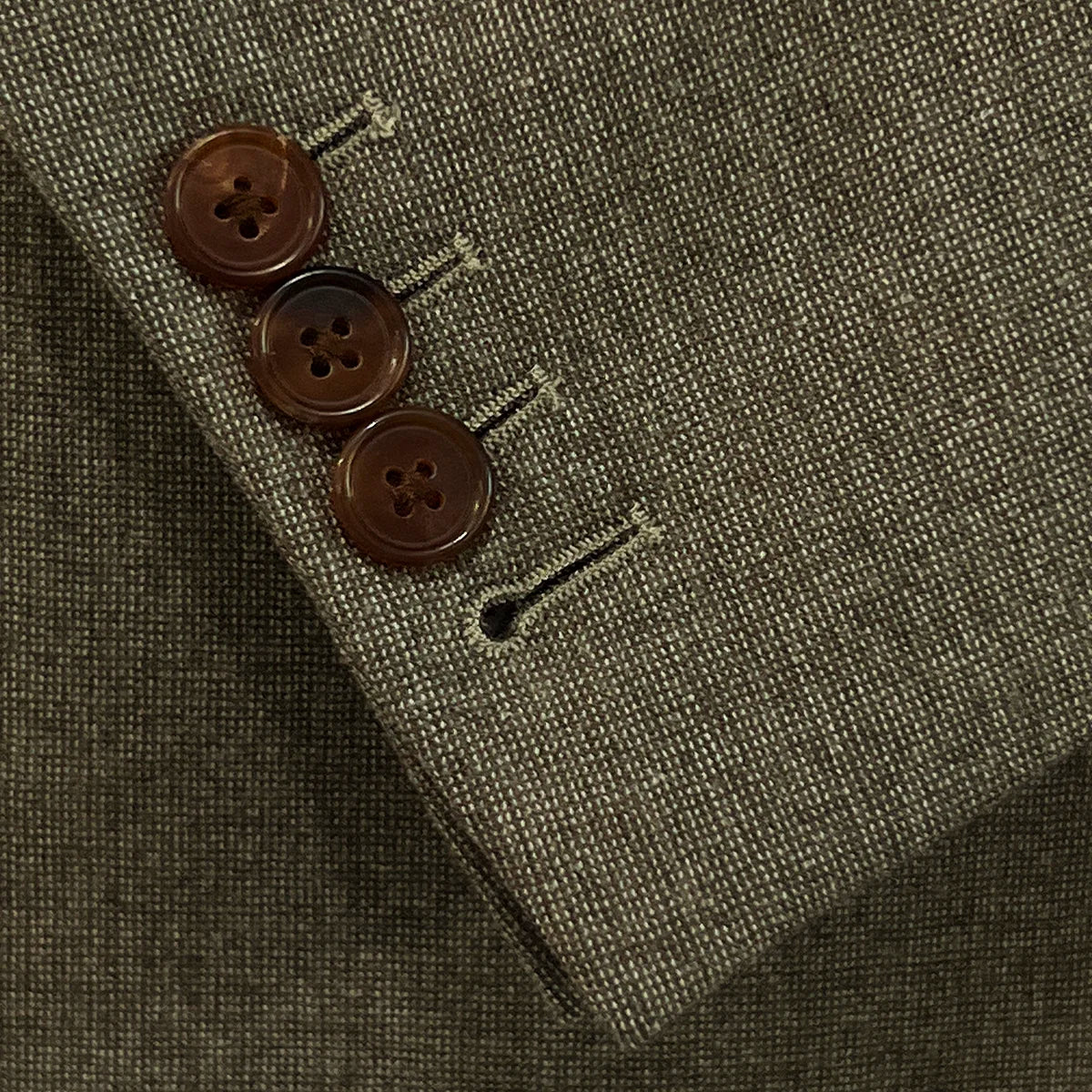 View of the functional sleeve buttonholes on the Westwood Hart brown nailhead men's suit jacket, showcasing the precise craftsmanship.