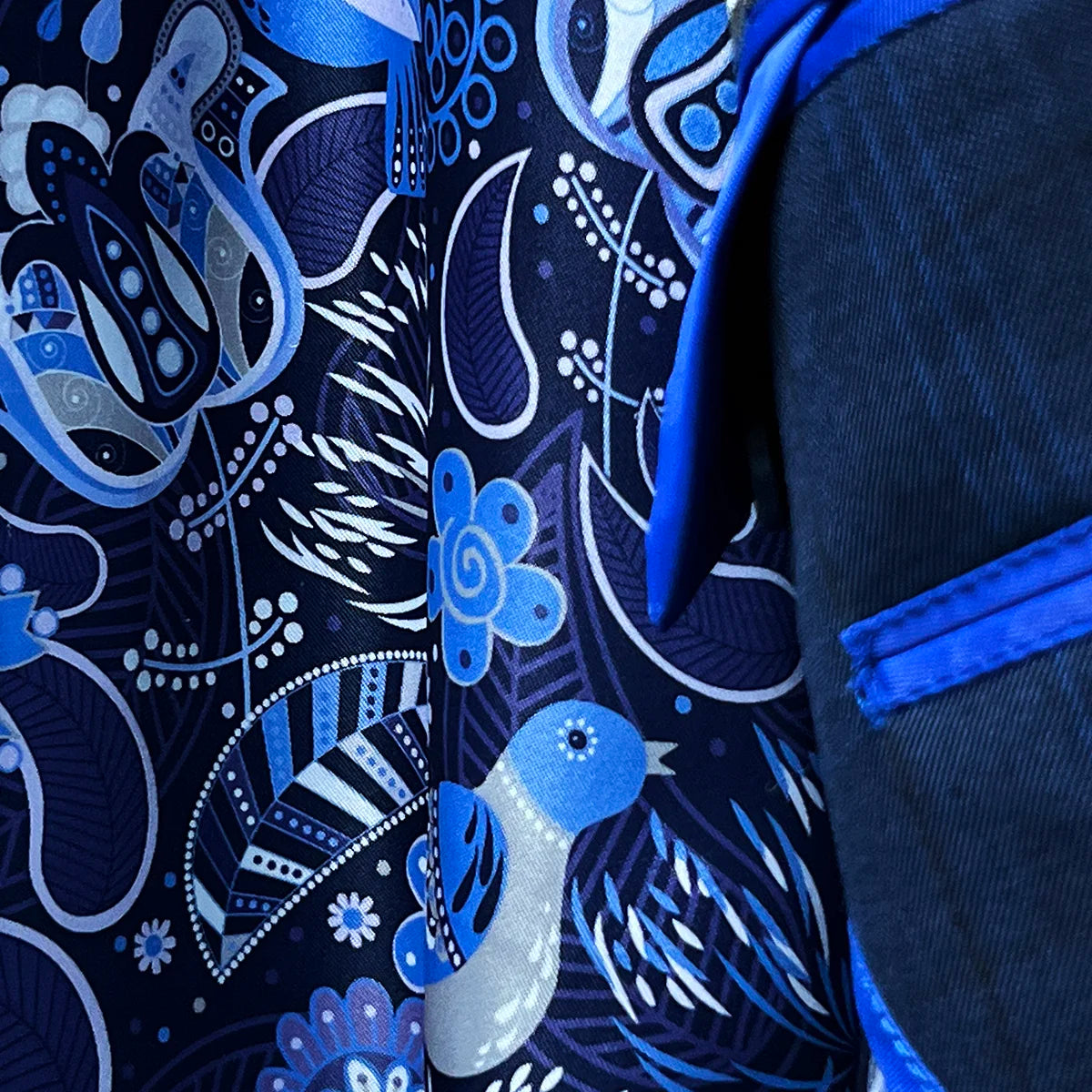 Interior view highlighting the flash linings of the dark blue windowpane men's sport coat with blue and white aviary motif.