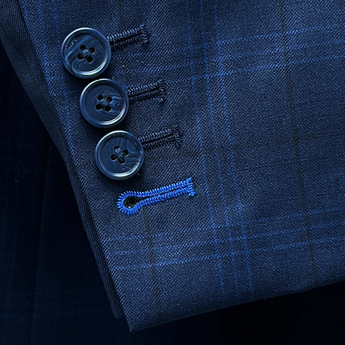 Close-up of the functional sleeve buttonholes on the dark blue windowpane men's sport coat with navy horn marble buttons.