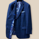 Interior view of the right side of the dark blue windowpane men's sport coat highlighting the blue and white aviary motif flash lining and royal blue piping.