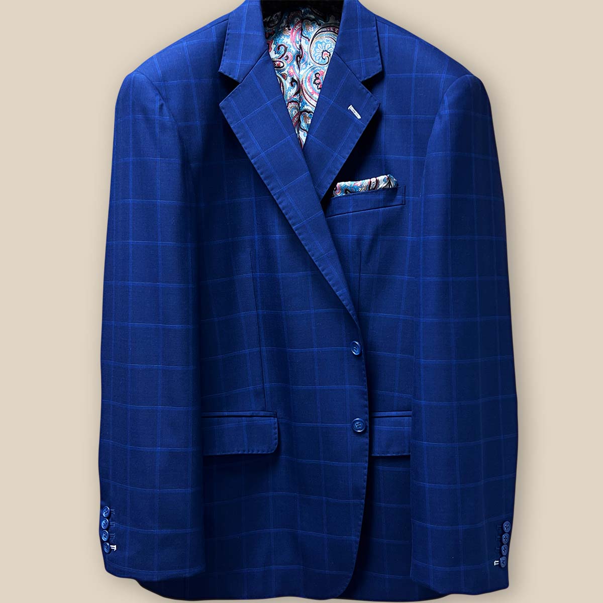 Detailed view of the jacket button panel with blue marble horn buttons on the royal blue fabric with navy and white windowpane design.