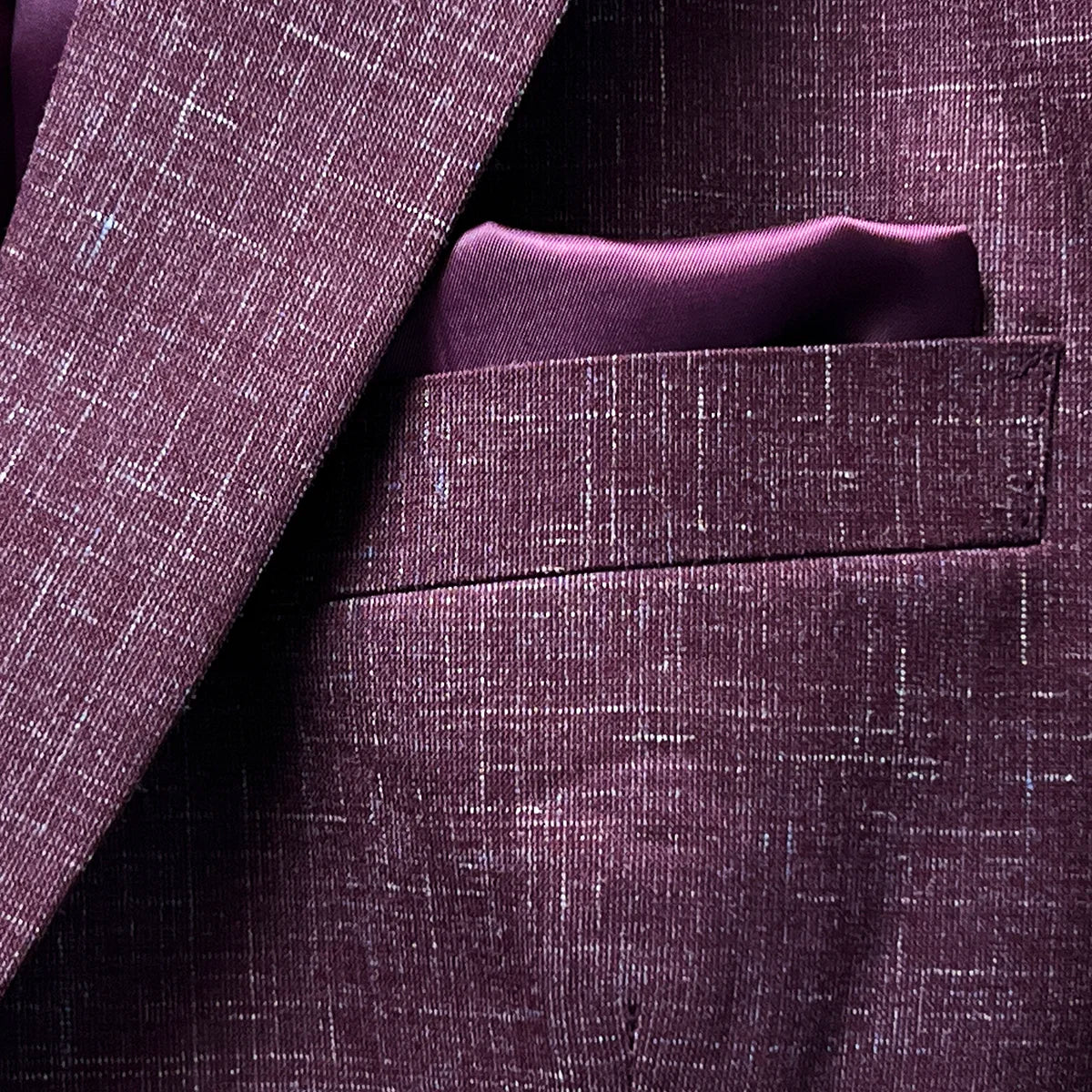 Built-in pocket square feature on a cranberry men's suit by Westwood Hart, adding a touch of elegance to the design.