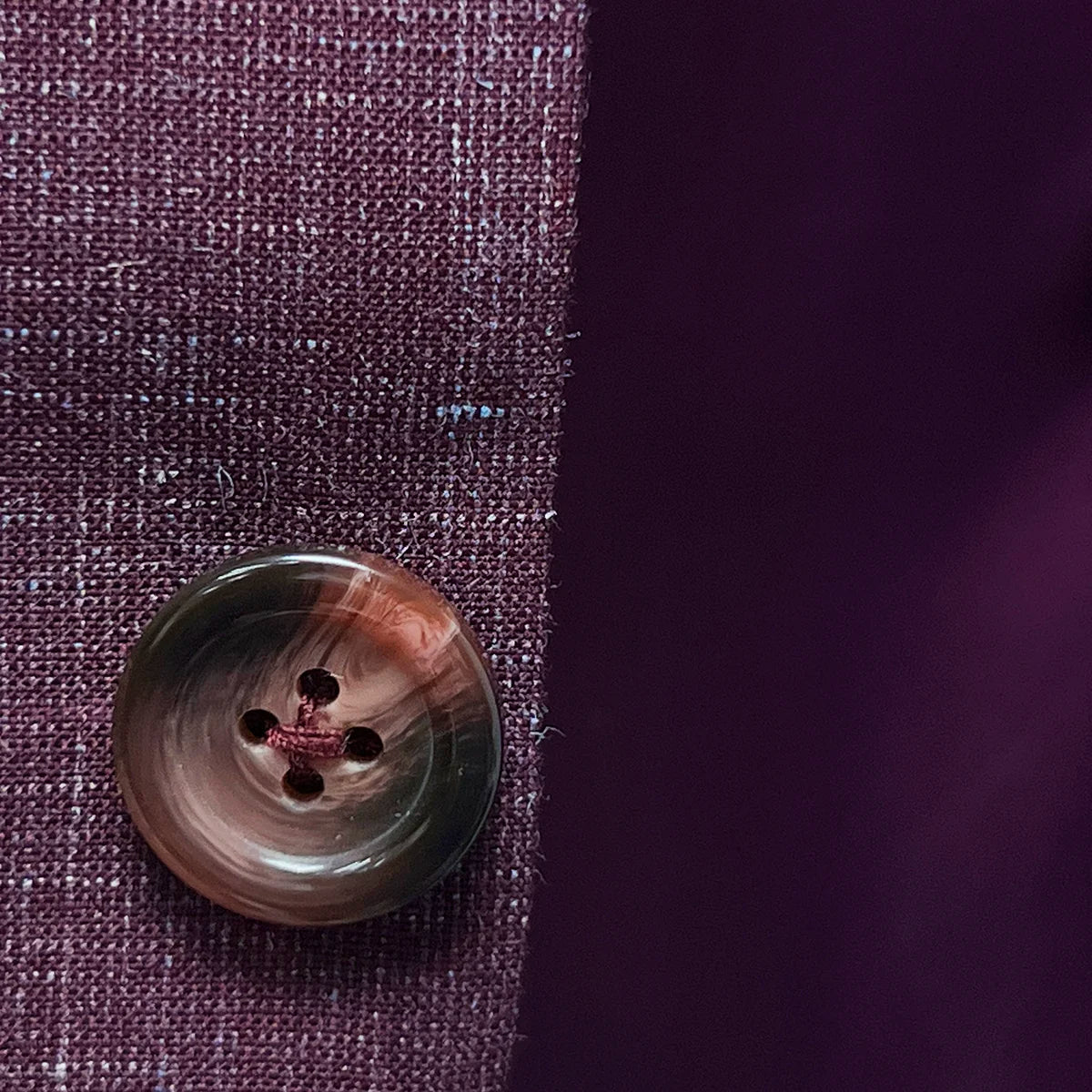 Burgundy horn buttons on a cranberry men's suit by Westwood Hart, highlighting quality and attention to detail.