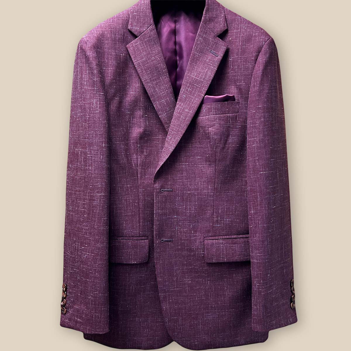 Close-up view of the jacket buttonhole panel on a cranberry men's suit by Westwood Hart, showcasing meticulous craftsmanship.