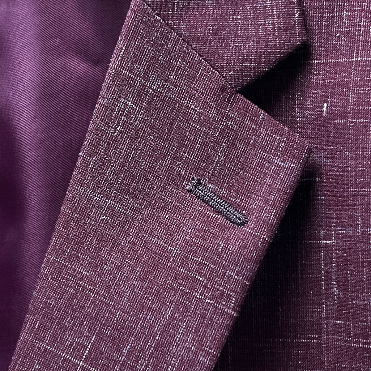 Notch lapel detail on a cranberry men's suit by Westwood Hart, reflecting classic tailoring and style.
