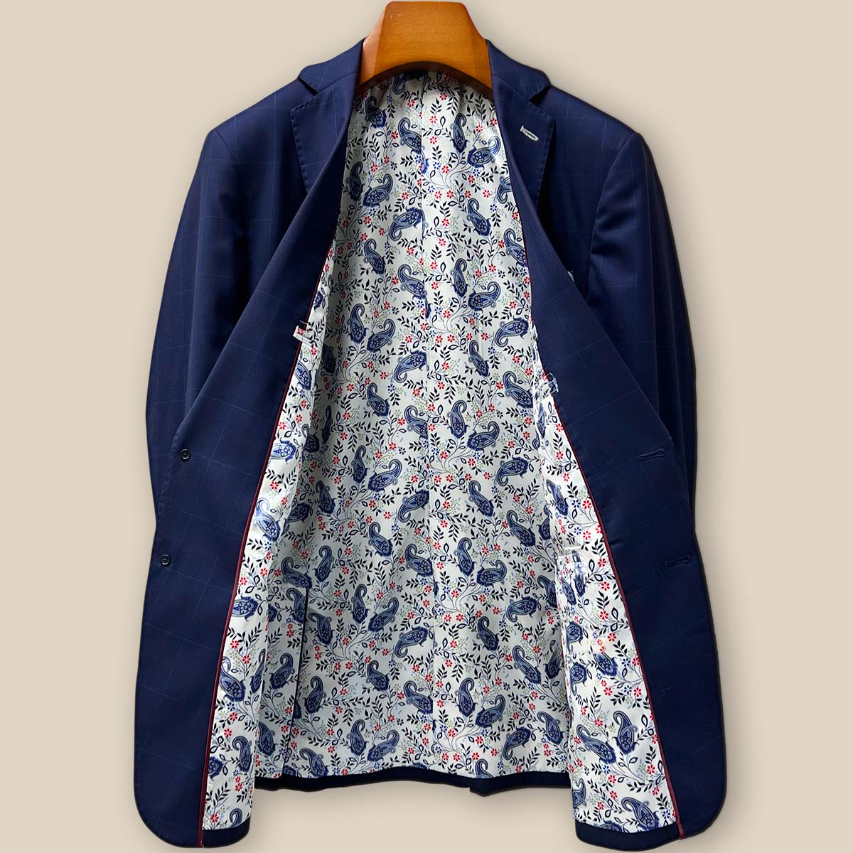 Full view of the luxurious white with navy and red paisley lining of the Westwood Hart suit, showing the craftsmanship of the interior construction