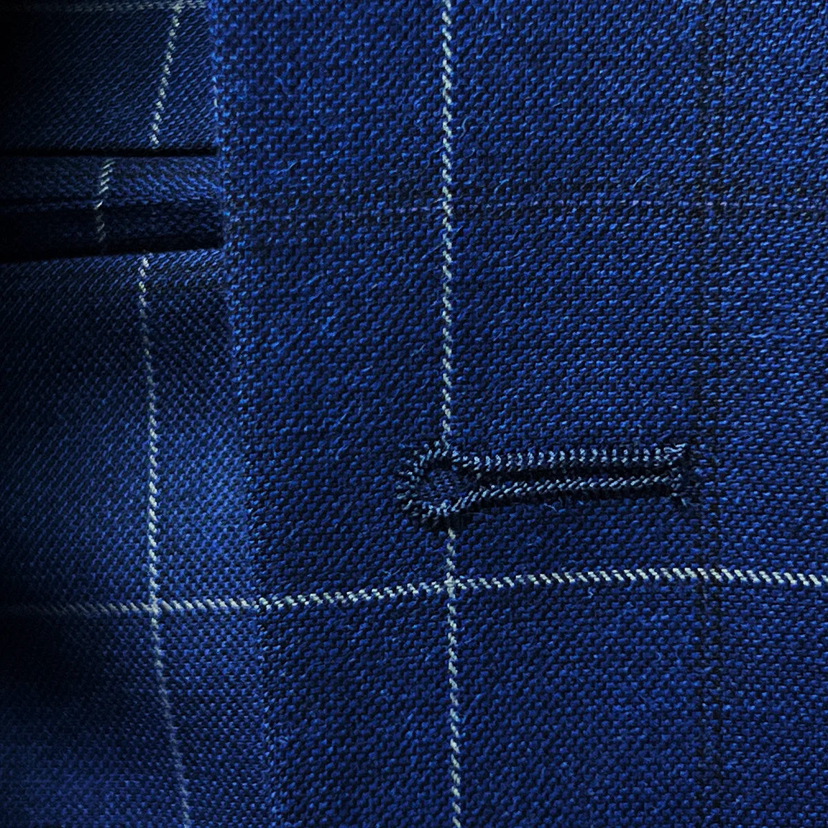 Close-up of buttonholes on a navy blue windowpane suit