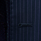 Close-up view of a buttonhole, a fine detail on a navy suit with purple pinstripes.