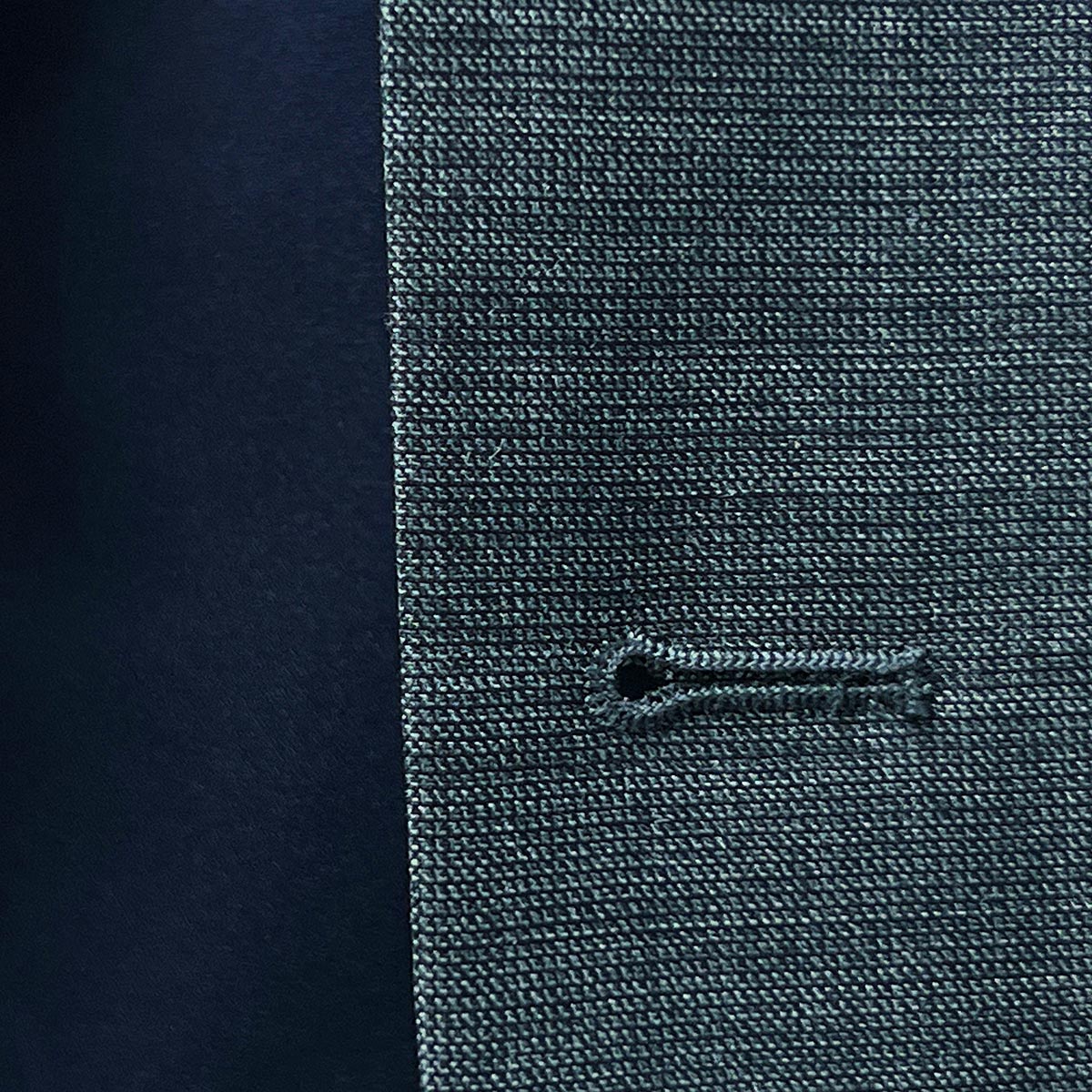 buttonholes adding a stylish flair to a dark grey nailhead suit.